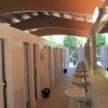 Interno di un bagno pubblico con lavandini e cabine, soffitto in legno arcuato.